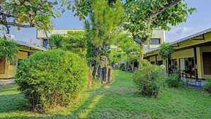 Une cour intérieure avec un chemin menant à un bâtiment comprenant plusieurs pièces.