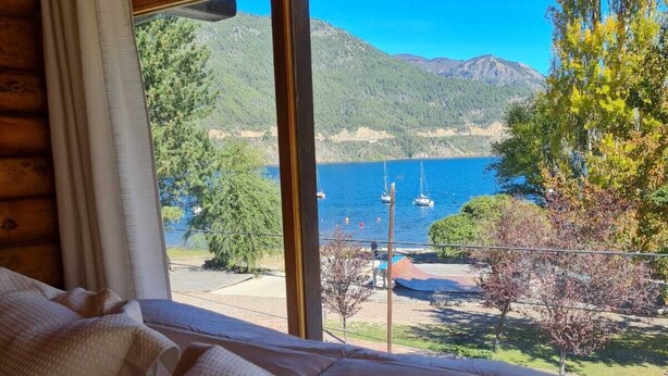 A bed with a view of a lake and mountains. - PUERTO LACAR LODGE SMARG (San Martín de los Andes)