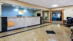 A reception area with a marble counter, a Dell computer, and a blue wall with a logo. - Suburban Studios Chester I-95, VA (Chester)