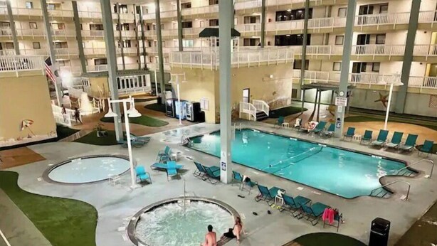 Ein Innenpoolbereich mit mehreren Pools, Liegestühlen und einem Whirlpool.