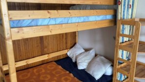 A bunk bed with a wooden frame, a blue mattress, and a patterned blanket. - 5-PERSON APARTMENT LA MONGIE AT THE FOOT OF THE SLOPES (Bagnères-de-Bigorre)