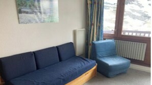 A room with a wooden sofa and a blue chair. - 5-PERSON APARTMENT LA MONGIE AT THE FOOT OF THE SLOPES (Bagnères-de-Bigorre)