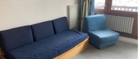 A room with a wooden sofa and a blue chair.