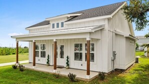 A single-story house with a covered porch and a garage. - Beach Cottage with a View!! (Gulfport)