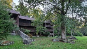 A rustic lodge with a two-story structure, a stone staircase, and a well-maintained lawn. - Mountain View Hideaway On A Golf course, Close To Downtown Gatlinburg, Sleeps 6 (Gatlinburg)