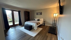 A bedroom with a bed, a nightstand, a dresser, a window with curtains, and a TV mounted on the wall. - Mountain View Hideaway On A Golf course, Close To Downtown Gatlinburg, Sleeps 6 (Gatlinburg)