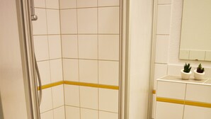 A bathroom with a shower, toilet, and sink. - Posthus Apartment 103, close to the beach and central (Borkum)