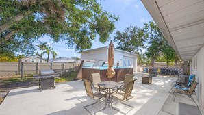 Una terrazza con barbecue, posti a sedere all'aperto e una vasca idromassaggio.