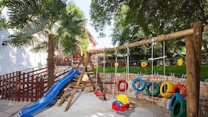 A playground with a blue slide, swings, and tire swings. - Holiday apartment with large garden and pool (Poreč)