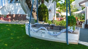 A rustic wooden boat hanging from a tree, with a QR code and a website URL. - Holiday apartment with large garden and pool (Poreč)