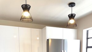 Eine moderne Küche mit Edelstahlgeräten, Holzschränken und Pendelleuchten.