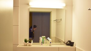 Ein Badezimmer mit Waschbecken, Spiegel und Toilettenartikeln.