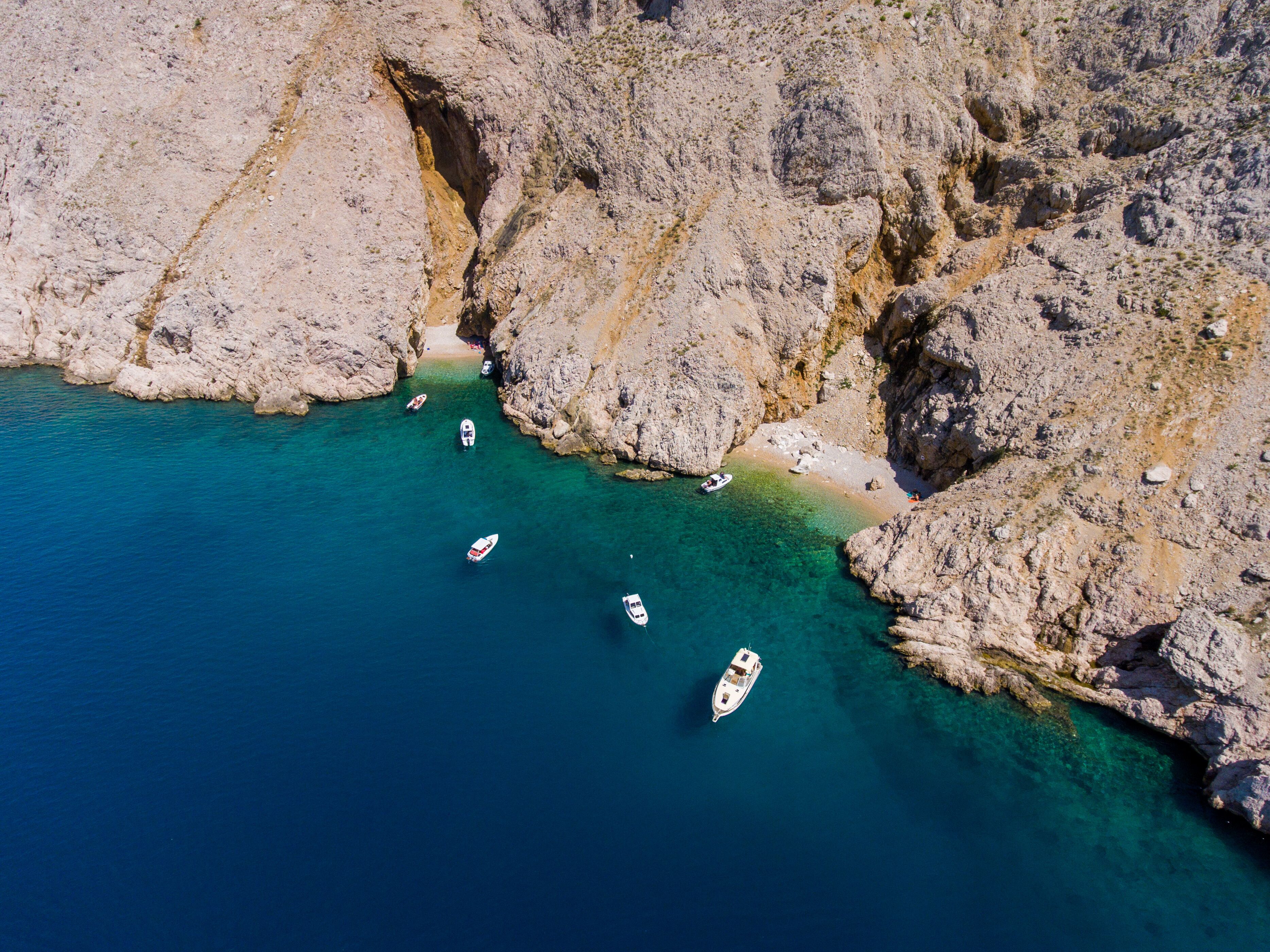 A coastal area with rocky cliffs and clear blue waters.