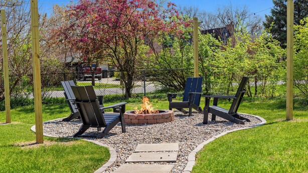 A fire pit area with seating and a gravel path. - Stylish, Cute & Homey Livonia Getaway (Livonia)