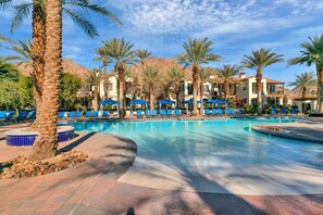 A swimming pool with blue lounge chairs and palm trees. - Stunning View, Perfectly Located 2BR (La Quinta)