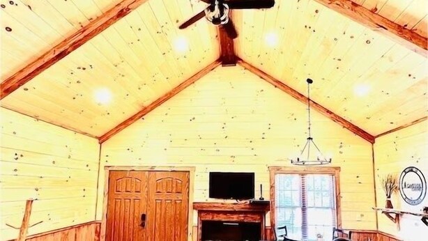 A rustic interior with a wooden ceiling, a ceiling fan, a bar area, and a fireplace. - LUXURY COUPLES CABIN! Caveside Cabins (Creola)