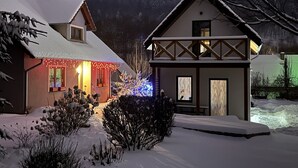 Ein mit Schnee bedecktes Haus mit einer sichtbaren Veranda und einem kleinen Schuppen.
