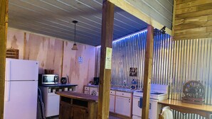Une cuisine compacte équipée d’un réfrigérateur, d’un four à micro-ondes et d’une cuisinière.