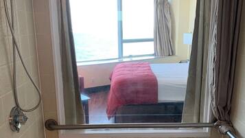 Een bad/douchecombinatie, een haardroger, handdoeken