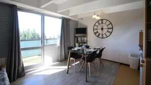En matplats med ett bord, stolar och en stor väggklocka.