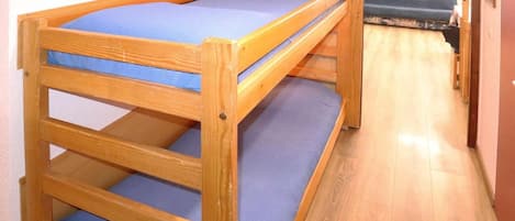 A bunk bed with a blue mattress and wooden frame.