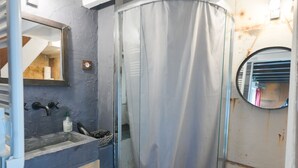 A bathroom with a wooden vanity, a glass shower enclosure, and a mirror. - Beautiful atypical hyper center loft (Nancy)