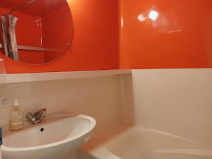 A bathroom with a white sink, a mirror, and a bathtub.