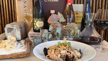 A seafood dish on a plate, a bottle of wine, and a menu board.