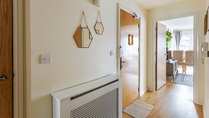 Un couloir avec un radiateur, une porte et une vue sur une salle à manger.
