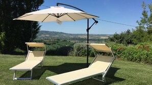Two sun loungers with attached umbrellas on a grassy lawn with a scenic view in the background. - Magnificent home vacation wifi solution, sea, beach, last minute (Marche)