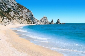 A beach with clear blue water and rocky cliffs. - Magnificent home vacation wifi solution, sea, beach, last minute (Marche)