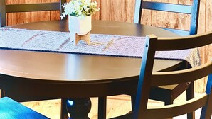 A wooden dining table with chairs, a potted plant, and a sign for 'Caveside Cabins At Hocking Hill'. - LUXURY COUPLES CABIN! Caveside Cabins (Creola)