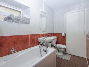 A bathroom with a bathtub, sink, and toilet.