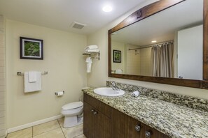 A bathroom with a sink, mirror, toilet, and towel rack.