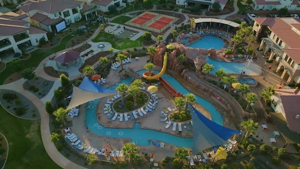 Ein Resort mit mehreren Swimmingpools, einer Wasserrutsche und Liegebereichen.