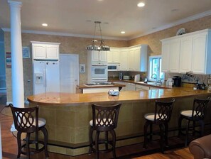 Enjoy cooking in this well-equipped kitchen with a central island, sink, and bar seating.