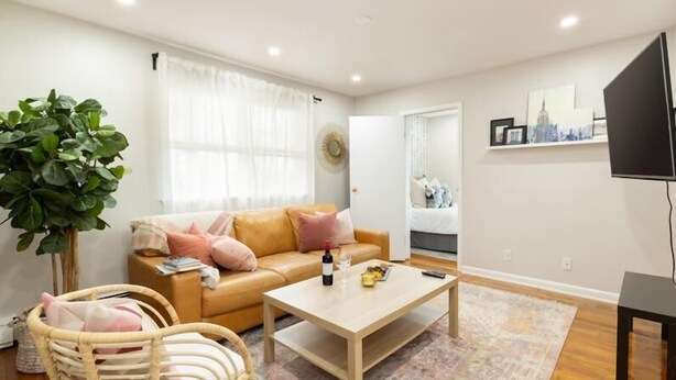 Ein Wohnzimmer mit einer Couch, einem Couchtisch und einer großen Pflanze.