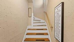 Una escalera con escalones de madera y un cartel en la pared con frases motivacionales.
