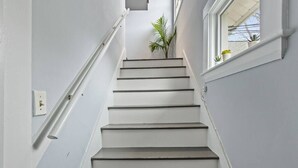 Portaat, joiden seinät ovat valkoiset ja oikealla puolella on ikkuna.