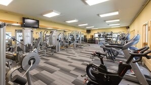 A gym with cardio machines, weight training equipment, and a television on the wall. - Spacious Condo/Mountain Views/Great Amenities (Keystone)
