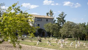 A building with a tiled roof, surrounded by a garden with young trees and a fenced area. - Charming farmhouse, surrounded by vineyards with a private pool in the  nature (Castellet i La Gornal)