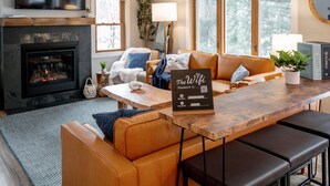 Una sala de estar acogedora con chimenea, un sofá, una mesa de centro y una zona de bar.