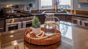 Una cocina con estufa de acero inoxidable, microondas y un ventanal grande.
