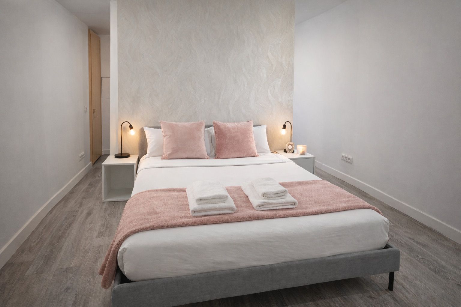 A modern bedroom with a bed, two bedside tables, and a nightstand.