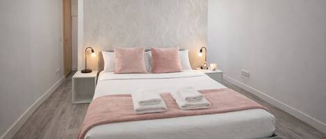 A modern bedroom with a bed, two bedside tables, and a nightstand.