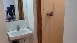 Un baño con lavamanos, espejo y ducha.
