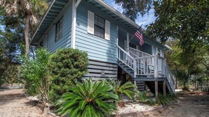 A two-story house with a porch and a staircase leading to the second floor.