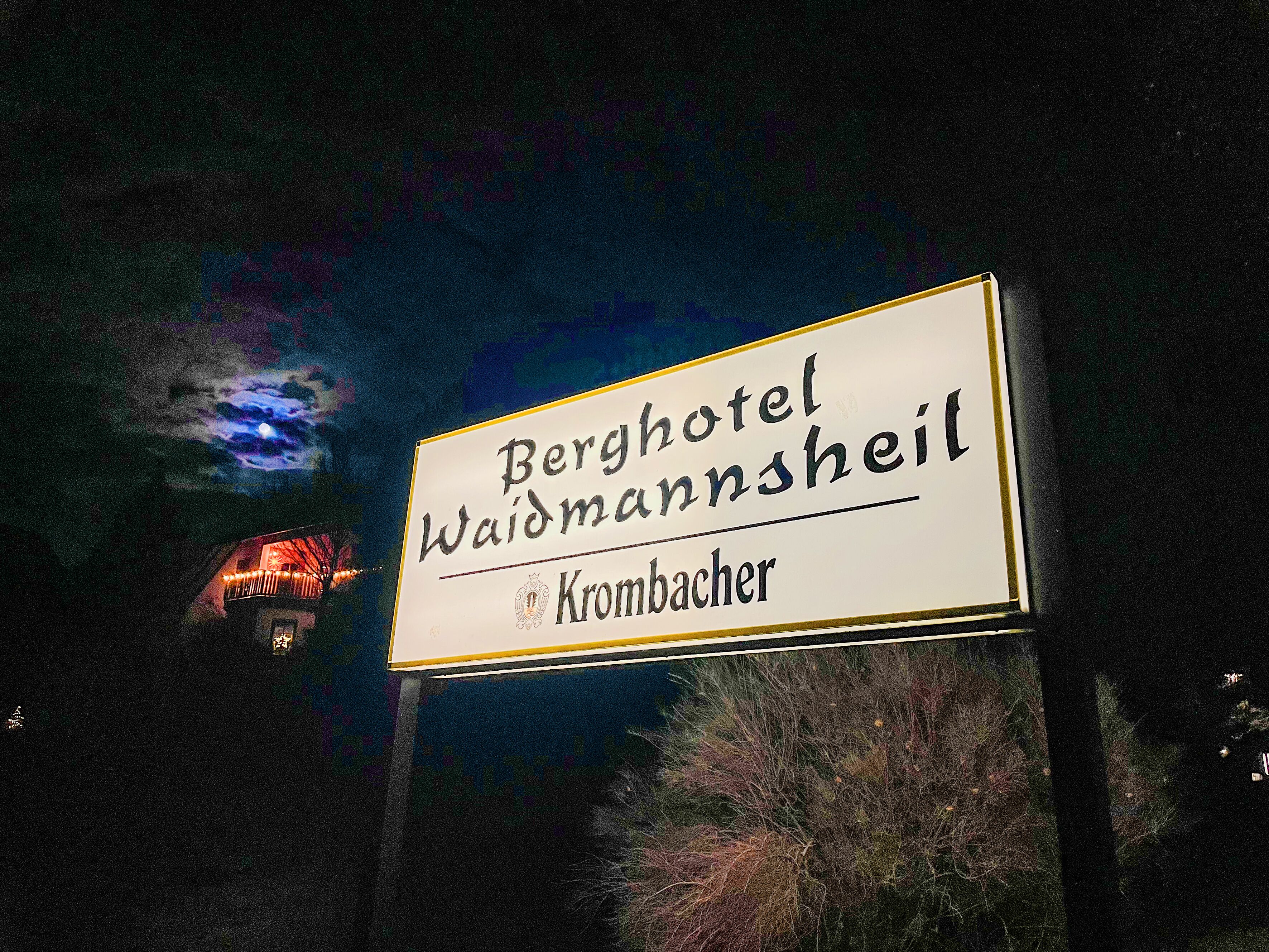 A sign for 'Berghotel Waldmannsheil' with the location 'Krombacher' below it.