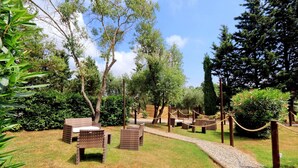 An outdoor seating area with wicker furniture and a gravel path. - Pimpinnacolo 1 - 2 BR M3 (Monte Argentario)