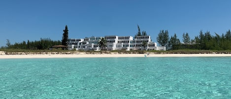 Un hôtel situé en bord de mer, doté de nombreux balcons offrant une vue sur l’océan.